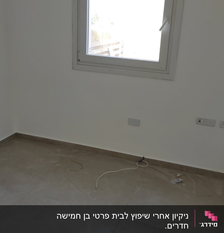 חדר ריק עם רצפה מלוכלכת וחוט חשמל